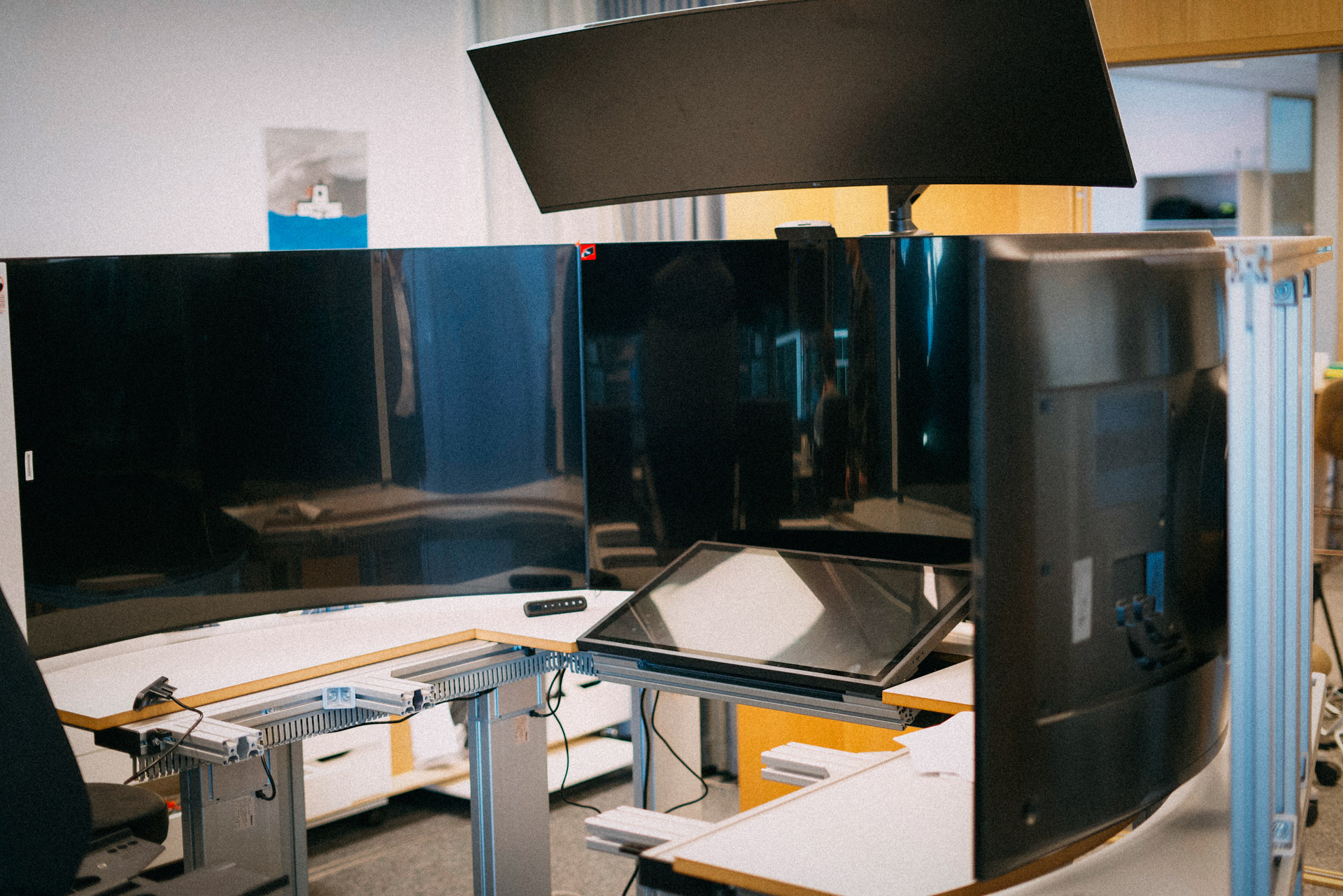 Hestesko-formet arbeidspult med 5 store dataskjermer.