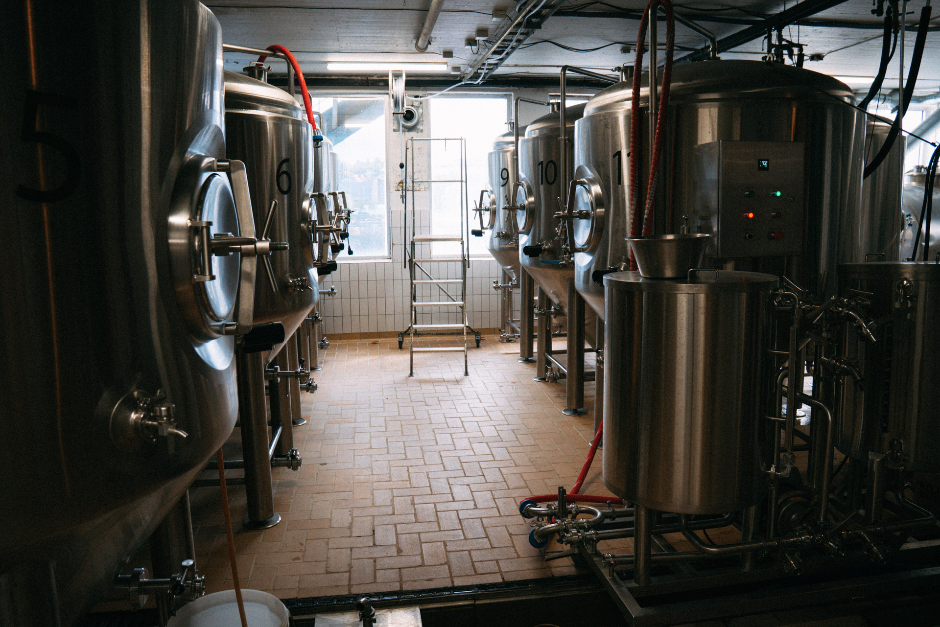 Store ståltanker til ølbrygging står på rekke i produksjonslokalet hos Monkey Brew.
