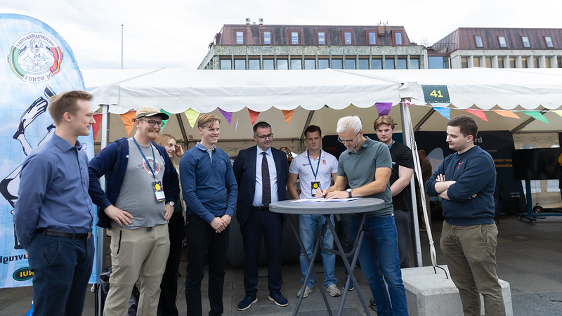 Daglig leder Erik Erlien signerer kontrakten omgitt av representanter fra studentorganisasjonene og ordfører Kent Ranum.