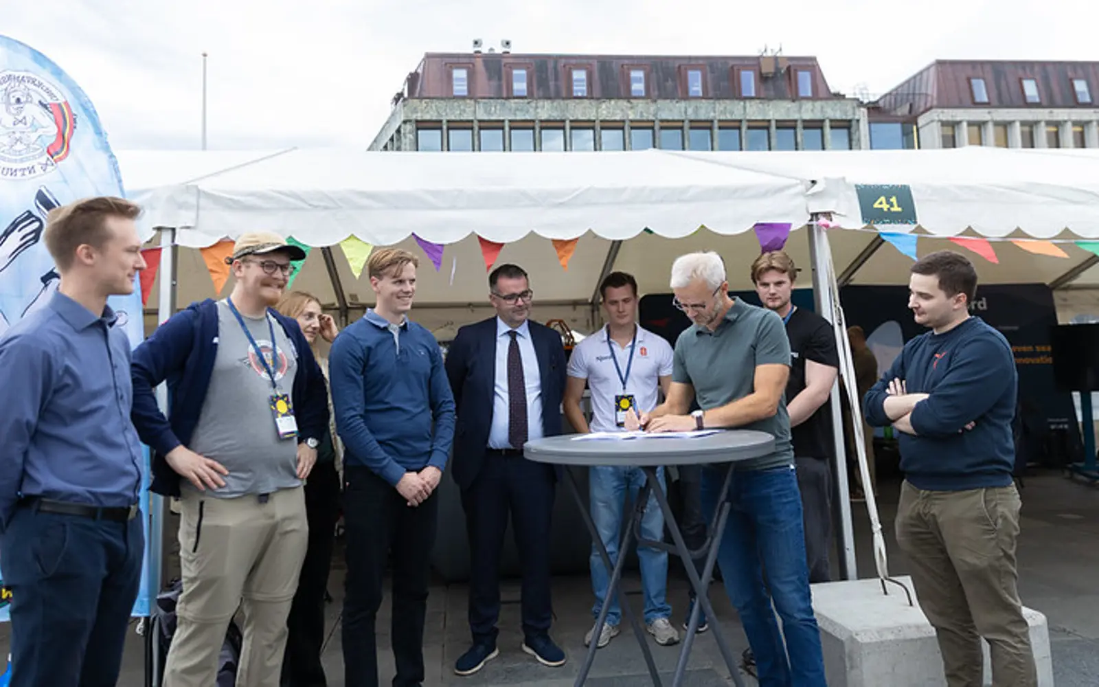Daglig leder Erik Erlien signerer kontrakten omgitt av representanter fra studentorganisasjonene og ordfører Kent Ranum.