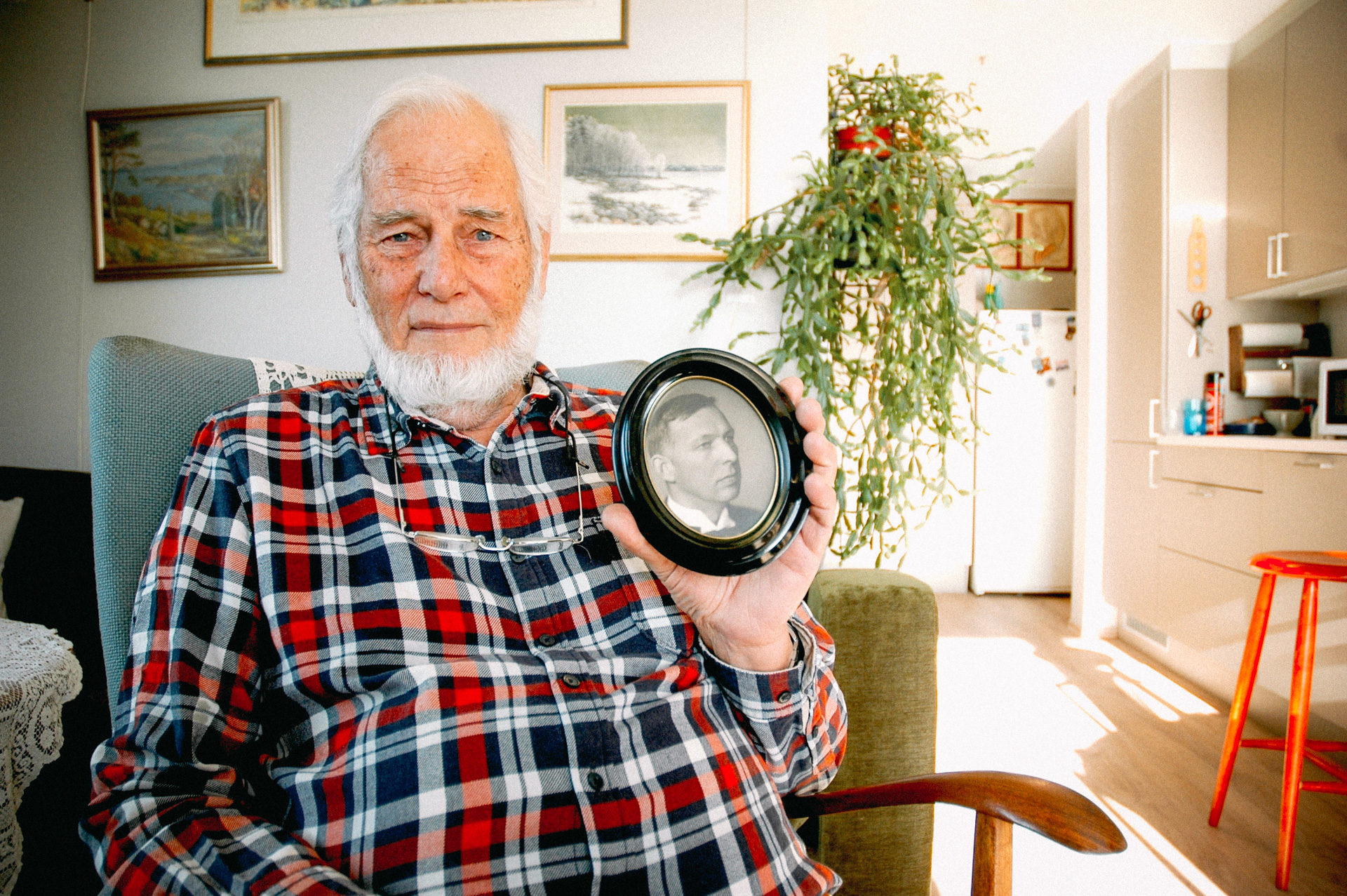 Tore Andreas Torp holder fram et innrammet portrett av morfaren Edvard Georg Møen.